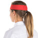 A woman wearing a red Headsweats headband.