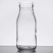 An American Metalcraft clear glass milk bottle with a lid.