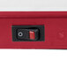 A close-up of a red and black switch on a Hatco heated shelf.