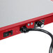 A close up of a red and black Hatco Glo-Ray portable heated shelf warmer with a cable attached.
