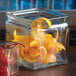 An American Metalcraft glass jar with orange peels and a cherry inside.