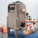 A woman pouring coffee into a Cambro insulated beverage dispenser.