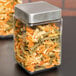 An Anchor Hocking glass jar filled with pasta with a brushed aluminum lid.