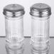 A clear glass caddy with two American Metalcraft Mini Glass Shakers with silver lids.