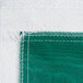 A green vinyl table cover with flannel back and white threads.
