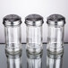 A Tablecraft clear glass condiment shaker with a silver top.