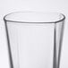 A close up of an Arcoroc clear glass with a curved edge and a black rim.