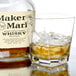 A glass of whiskey with ice and an Arcoroc double old fashioned glass next to a bottle of Maker's Mark.