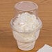 A Fabri-Kal clear plastic dome lid on a cup of ice cream.