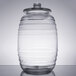 A clear glass Libbey barrel jar with a lid on a table.