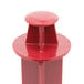 A red plastic Robot Coupe small vegetable pusher with a round top.
