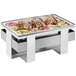 A stainless steel Cal-Mil Luxe roll top chafer with food on a tray.