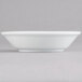An Arcoroc Rondo white bowl on a gray surface.
