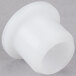 A white plastic guide bushing on a gray surface.
