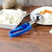 A Vollrath ice cream scooper with a blue handle next to a bowl of mashed potatoes.