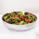 A salad in an American Metalcraft hammered stainless steel bowl.
