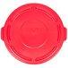 A red plastic lid for a Rubbermaid BRUTE trash can with handles.