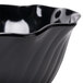 A close-up of a black Cambro swirl bowl with wavy edges.