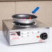 An APW Wyott Workline single open burner portable electric hot plate with a pan on it.