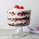 An Anchor Hocking glass trifle bowl filled with a trifle with strawberries and whipped cream.