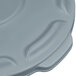 A close-up of a grey plastic lid with a handle.