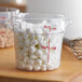 A Cambro round plastic food storage container filled with white marshmallows.