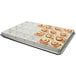 A tray of cinnamon rolls in a MFG Tray full-size pan extender.