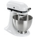 A white KitchenAid stand mixer with a KitchenAid stainless steel mixing bowl.