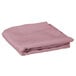 A folded pink Intedge 64" round table cover.