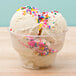 A clear Fabri-Kal PET sundae cup filled with a scoop of ice cream and sprinkles.