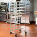 A Winholt metal rack with ten aluminum trays of food.