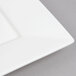 An Arcoroc white porcelain square plate with a white border.