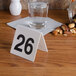 A table number 26 on a table with a glass of water and nuts.