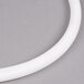 A white circular top gasket for a Cambro Ultra Camtainer on a gray surface.