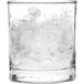 A glass of water with flake ice in it on a white background.