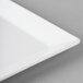 A close-up of a white Cal-Mil melamine square platter with a white edge.