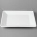 A white square Cal-Mil melamine platter on a gray surface.
