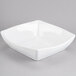 A white Cal-Mil melamine rounded square bowl on a gray surface.