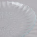 A clear glass plate with a circular flower design.