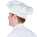 A man wearing a white Chef Revival chef hat.