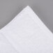 An Oxford Signature white hand towel with a white edge on a gray surface.