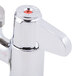 A chrome Equip by T&S deck-mounted faucet with 4 red lever handles.