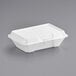 A Dart white styrofoam take out container with a perforated hinged lid.