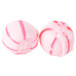 Two pink and white hard peppermint balls.