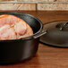 A Lodge Pro-Logic cast iron Dutch oven with a cooked ham inside.
