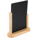 An American Metalcraft natural wood-finish table top board with a black board on a wooden stand.