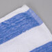 An Oxford blue and white striped pool towel on a table.
