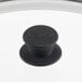 A Lodge tempered glass lid with a black knob on a white surface.