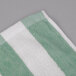 A close up of a green and white striped Oxford pool towel.