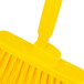 A close up of a yellow Carlisle Sparta Spectrum Duo-Sweep broom with a fiberglass handle.
